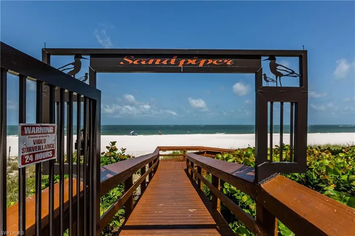 Dock area featuring a beach view and a water view