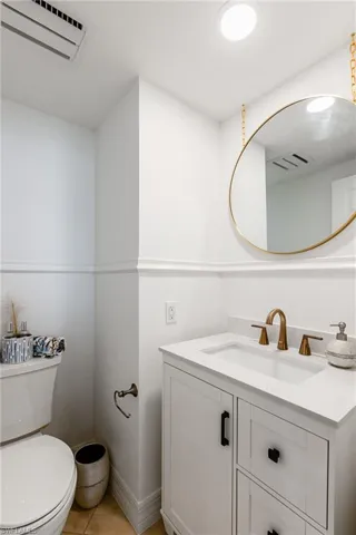 Bathroom featuring vanity, toilet, and tile patterned flooring