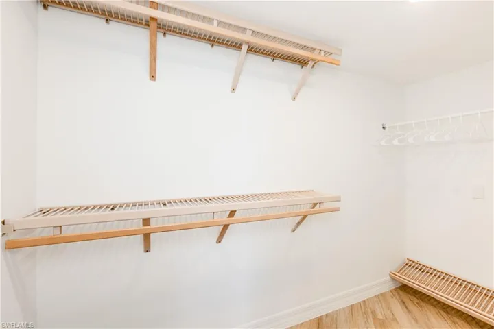 Walk in closet with wood-type flooring