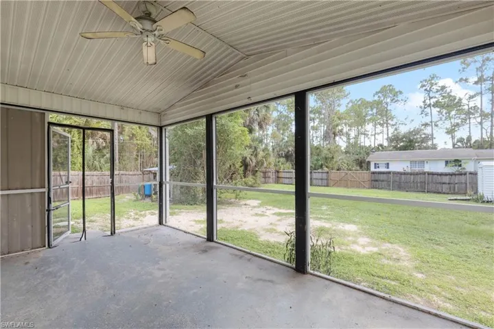 Unfurnished sunroom featuring lofted ceiling and ceiling fan