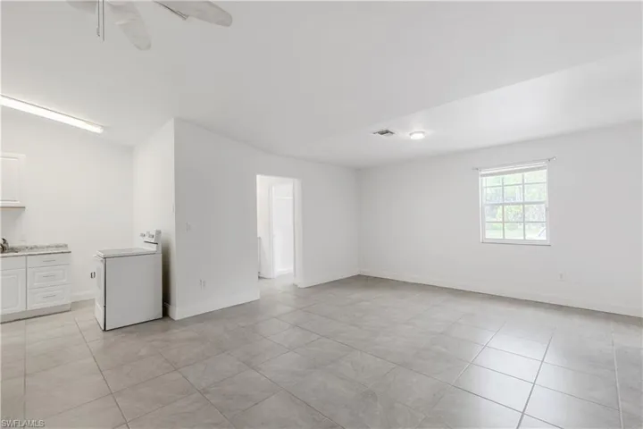 Spare room featuring ceiling fan, washer / clothes dryer, light tile patterned floors, and sink