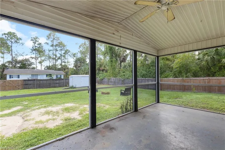 Unfurnished sunroom with lofted ceiling and ceiling fan
