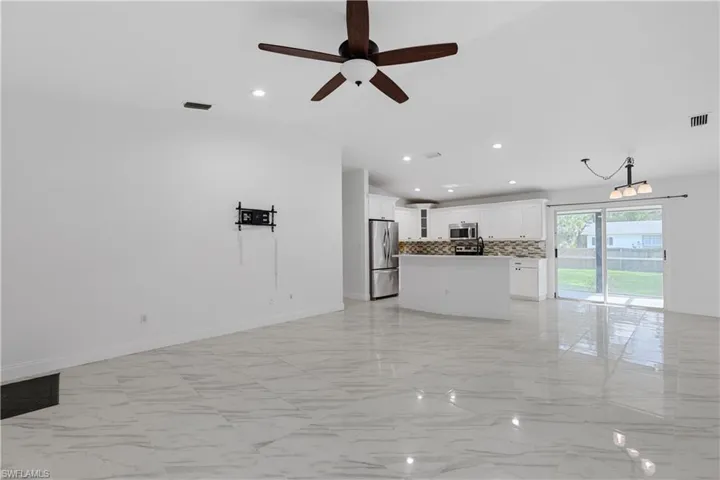 Unfurnished living room featuring lofted ceiling and ceiling fan