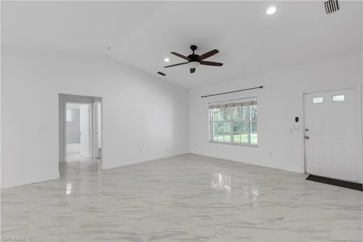 Foyer entrance featuring lofted ceiling and ceiling fan