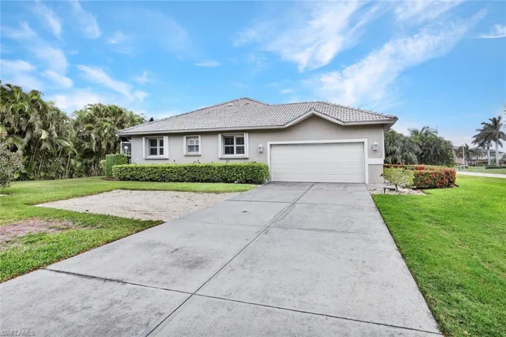 Ranch-style house with a garage and a front lawn