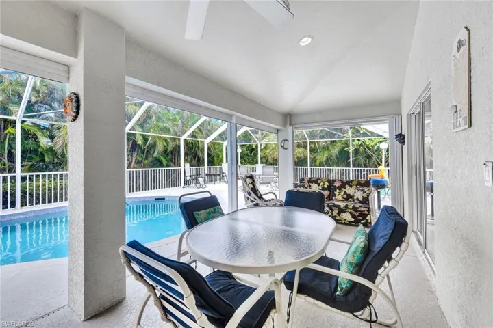 Sunroom / solarium featuring a swimming pool, a healthy amount of sunlight, and vaulted ceiling