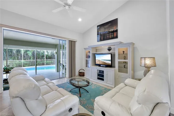 Tiled living room featuring high vaulted ceiling and ceiling fan