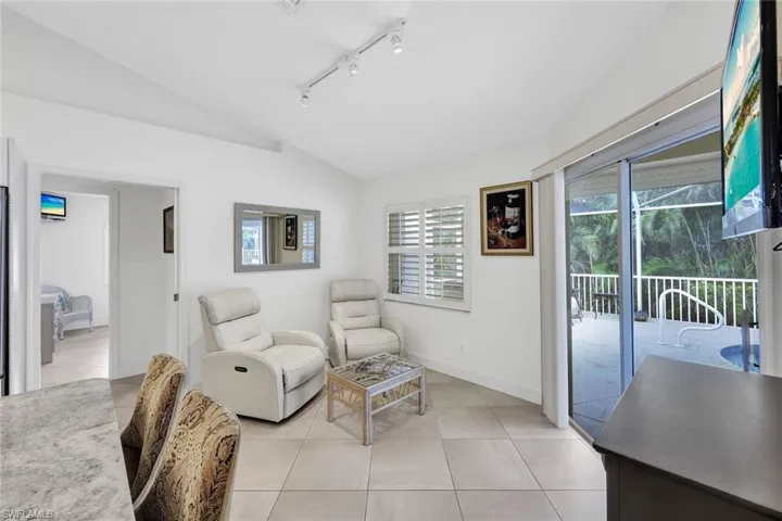 Sitting room featuring track lighting, vaulted ceiling, and light tile patterned flooring
