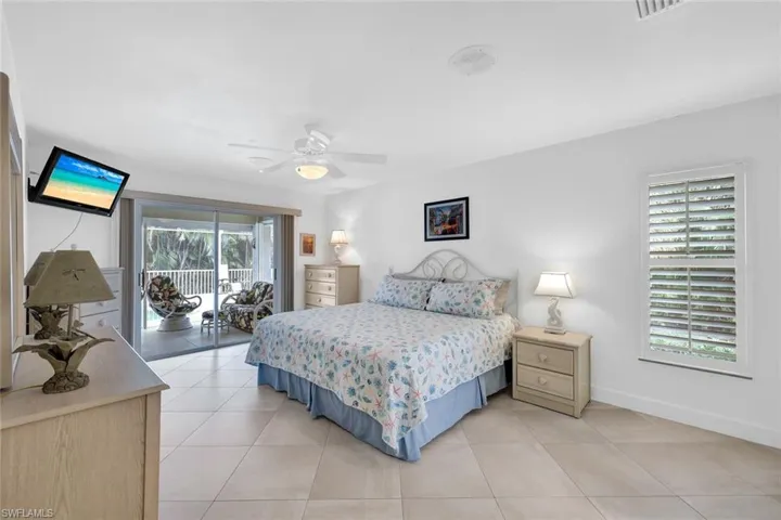 Bedroom with access to exterior, ceiling fan, and light tile patterned floors