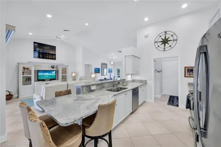 Kitchen featuring white cabinets, a breakfast bar, sink, and stainless steel appliances