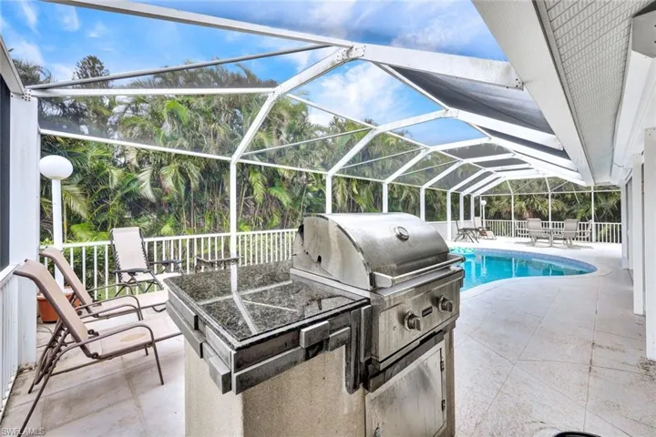 View of patio / terrace with an outdoor kitchen, glass enclosure, and grilling area