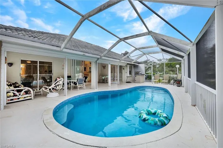 View of pool with glass enclosure and a patio area