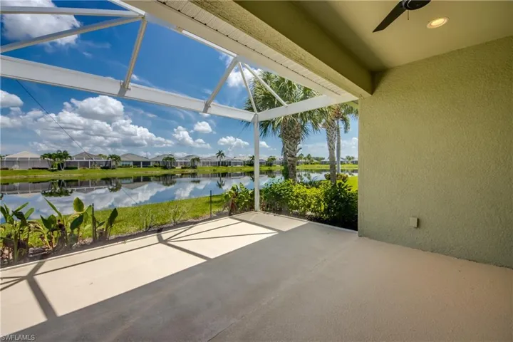 Unfurnished sunroom featuring ceiling fan and a water view