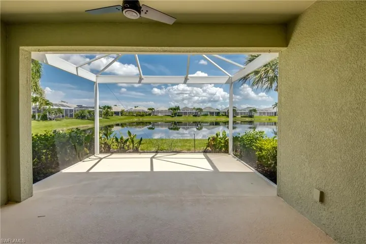 Unfurnished sunroom featuring ceiling fan and a water view