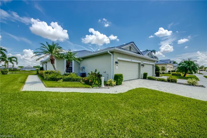 View of front of house with central air condition unit, a front yard, and a garage