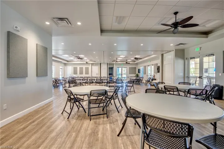 Dining space with ceiling fan, light wood-type flooring, a tray ceiling, and plenty of natural light