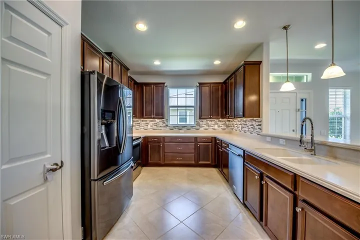 Kitchen featuring appliances with stainless steel finishes, sink, backsplash, and a healthy amount of sunlight