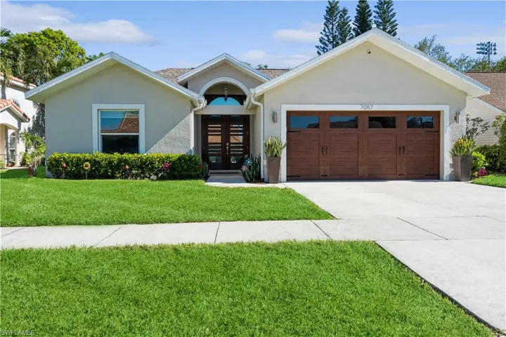 Ranch-style house with french doors, stucco siding, a front lawn, driveway, and a garage