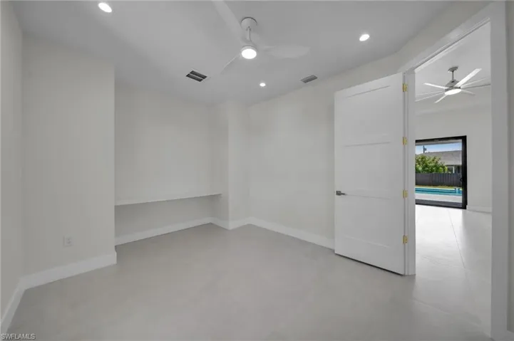 Empty room featuring ceiling fan, recessed lighting, and concrete flooring