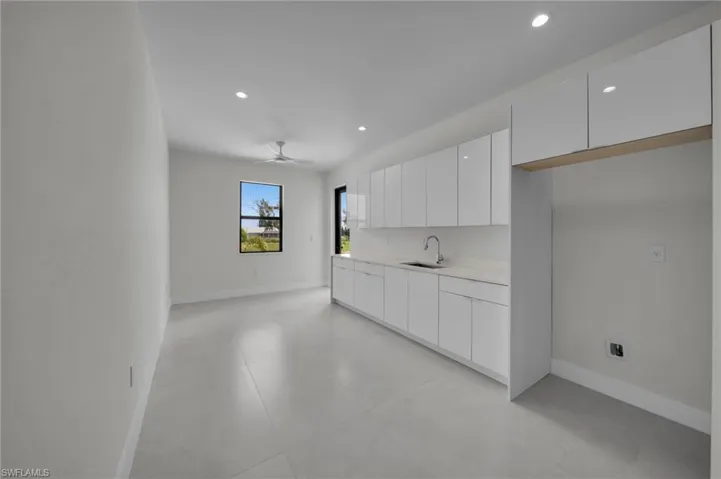 Kitchen featuring modern cabinets, white cabinetry, recessed lighting, a ceiling fan, and light countertops