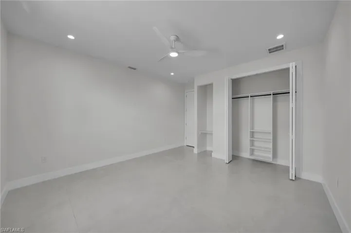 Unfurnished bedroom with finished concrete flooring, recessed lighting, a closet, and a ceiling fan
