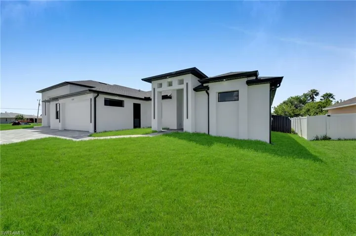 Prairie-style house with a garage, stucco siding, and driveway