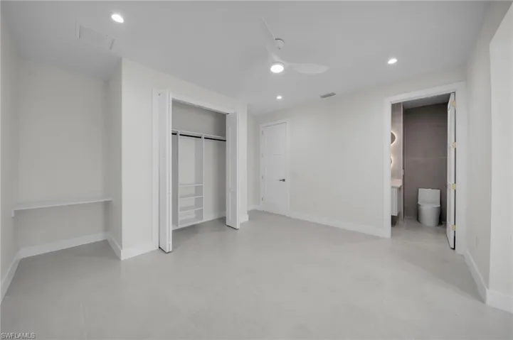 Unfurnished bedroom featuring recessed lighting, a closet, ensuite bathroom, and ceiling fan