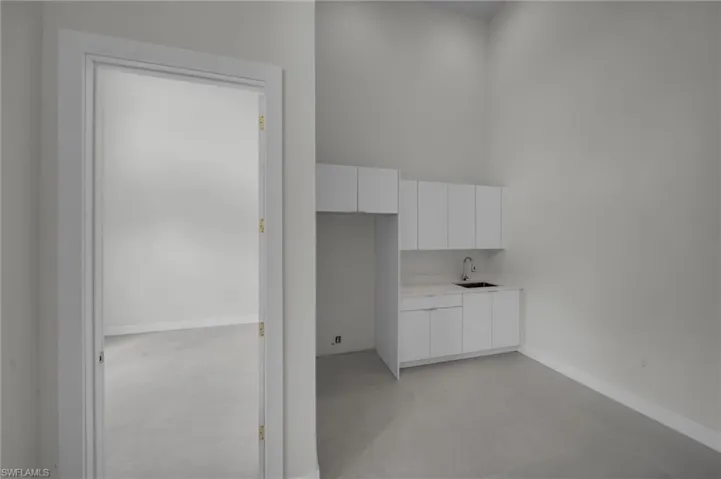 Hallway featuring a sink and concrete floors