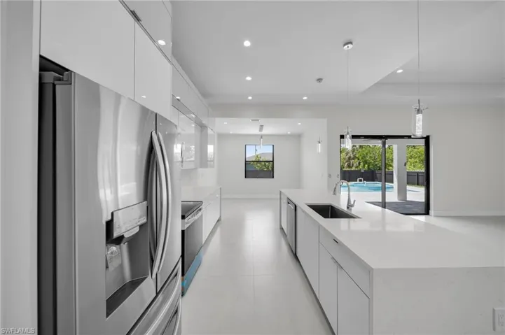 Kitchen with appliances with stainless steel finishes, modern cabinets, recessed lighting, white cabinetry, and a large island with sink