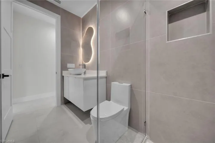 Full bath with tile walls, vanity, and tile patterned flooring