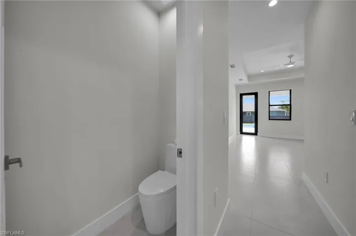 Bathroom featuring tile patterned flooring, recessed lighting, and a tray ceiling