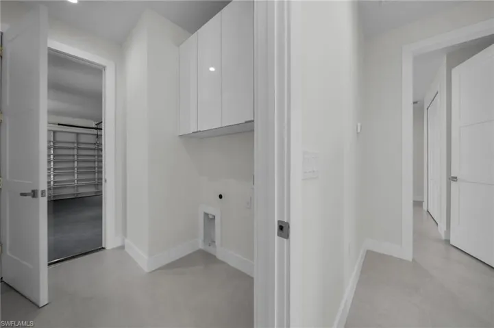 Laundry room with electric dryer hookup and cabinet space
