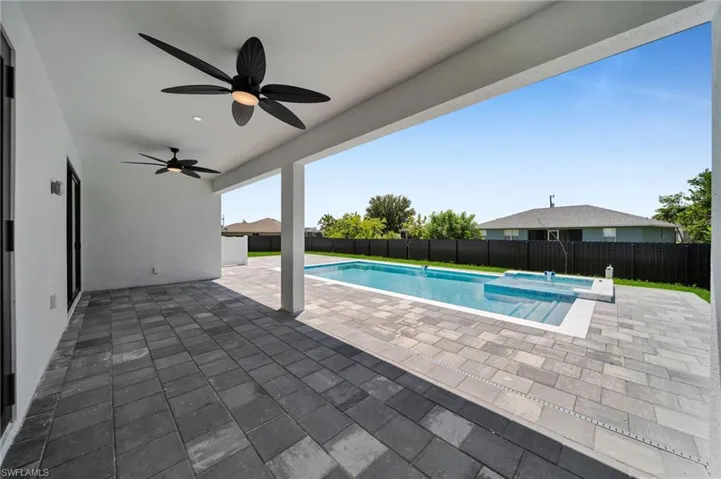 View of pool with a fenced backyard, a ceiling fan, and a patio