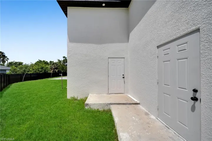 Doorway to property featuring stucco siding