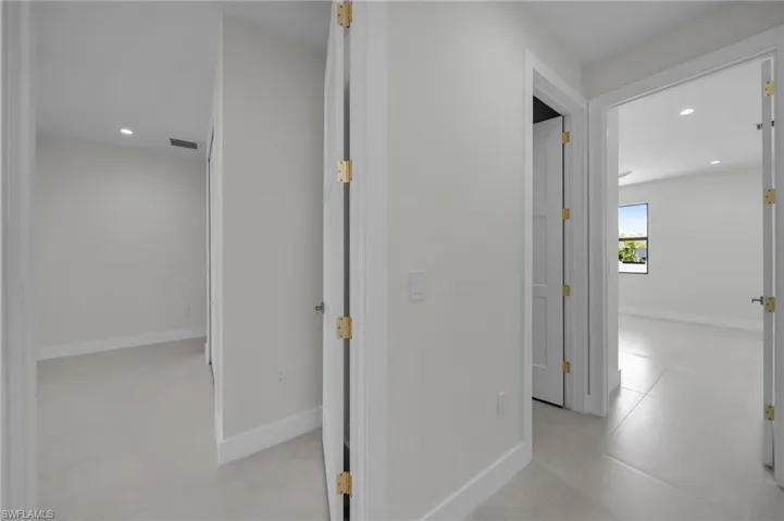 Corridor with recessed lighting and baseboards