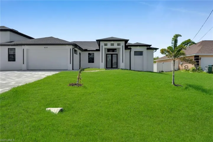 Prairie-style home with a garage, stucco siding, and driveway