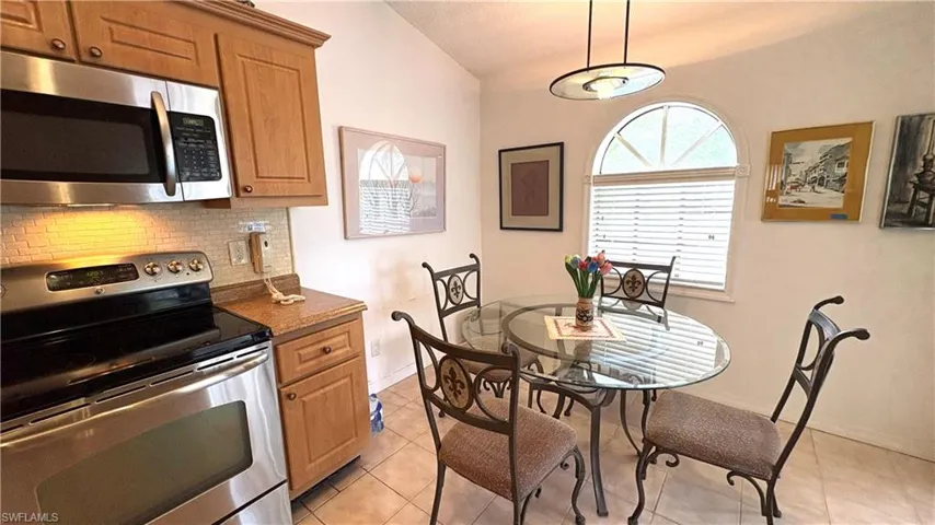 Eat-in Kitchen has NEWER stainless steel appliances, granite counters, decorative backsplash, light tile patterned floors, and raised-panel cabinetry.
