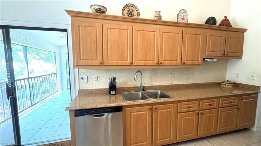 Your Eat-in Kitchen features a lovely water view from the spacious screened balcony  PLUS all NEWER stainless steel appliances, including dishwasher, microwave, refrigerator with ice-maker, and self-cleaning range. Note the decorative backsplash, raised-panel cabinetry, and granite counters!