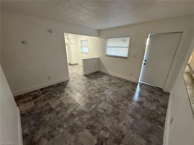 Entrance foyer featuring a textured ceiling and baseboards