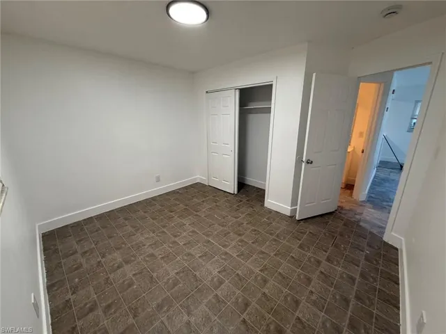 Unfurnished bedroom with a closet and baseboards
