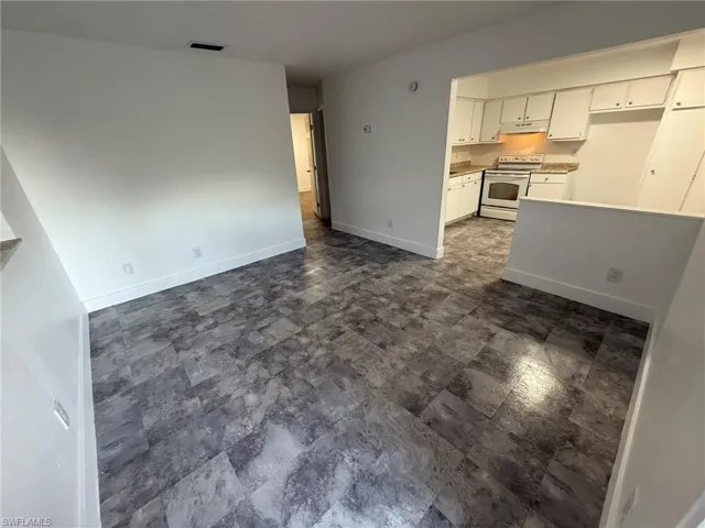 Unfurnished living room with baseboards