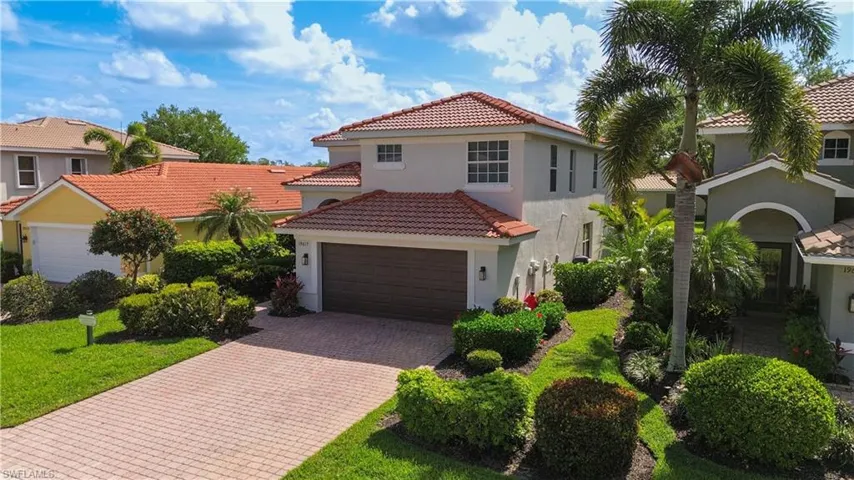 Mediterranean / spanish home featuring a tiled roof, decorative driveway, stucco siding, a garage, and a residential view