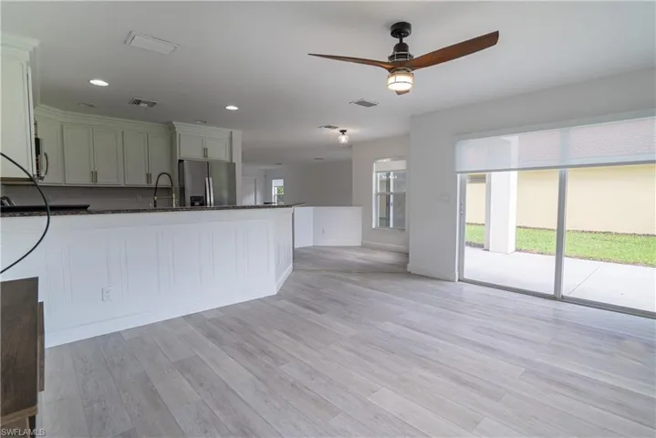 Kitchen featuring stainless steel appliances, ceiling fan, recessed lighting, dark stone counters, and a peninsula