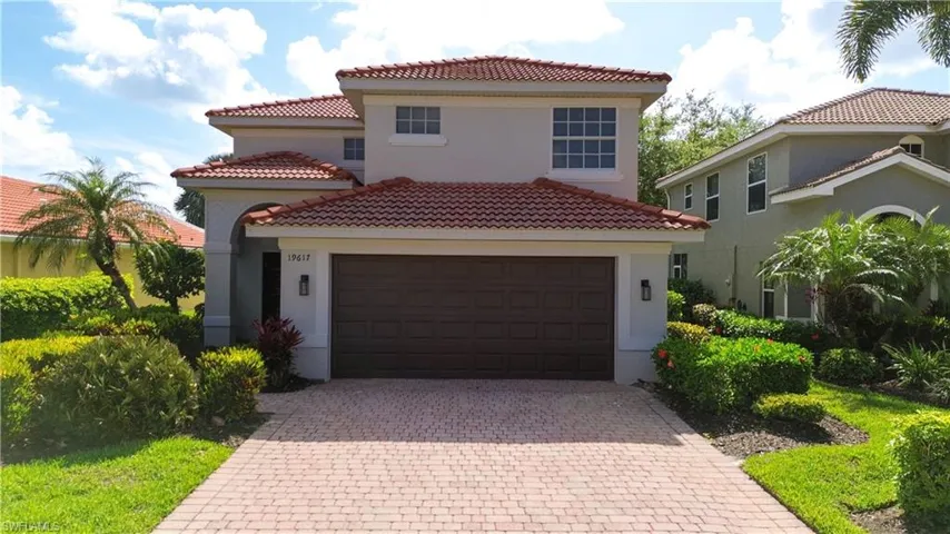 Mediterranean / spanish home featuring a tiled roof, decorative driveway, stucco siding, a garage, and a residential view