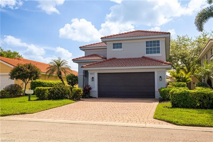 Mediterranean / spanish home featuring decorative driveway, stucco siding, a tiled roof, and a front yard