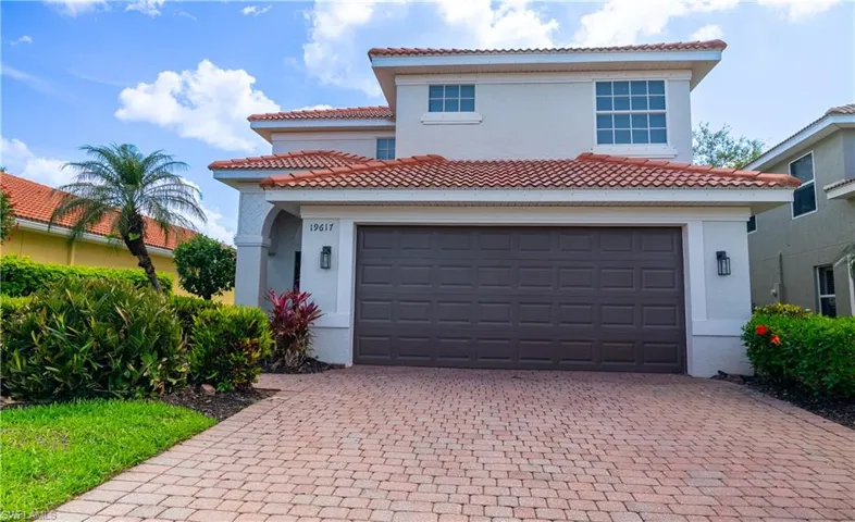 Mediterranean / spanish house with decorative driveway, stucco siding, a tiled roof, and an attached garage