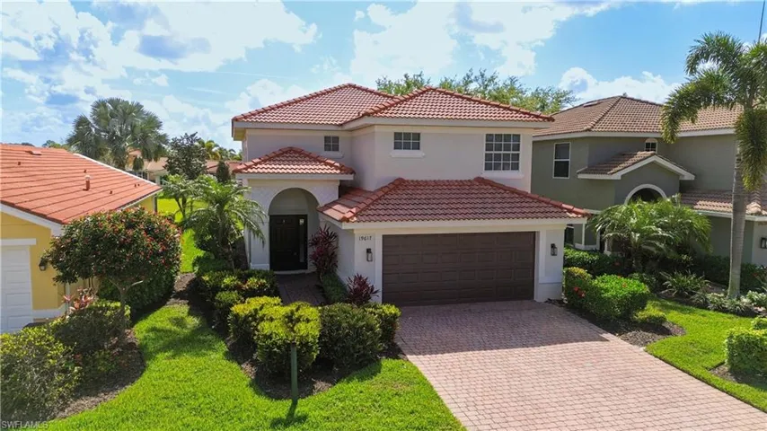 Mediterranean / spanish-style home with decorative driveway, stucco siding, a tiled roof, an attached garage, and a front yard