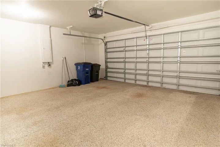 Garage featuring electric panel and a garage door opener