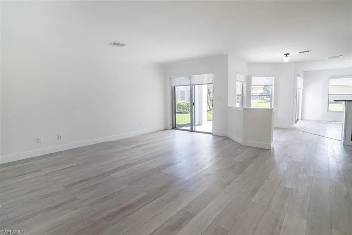 Unfurnished room with light wood-style floors and crown molding