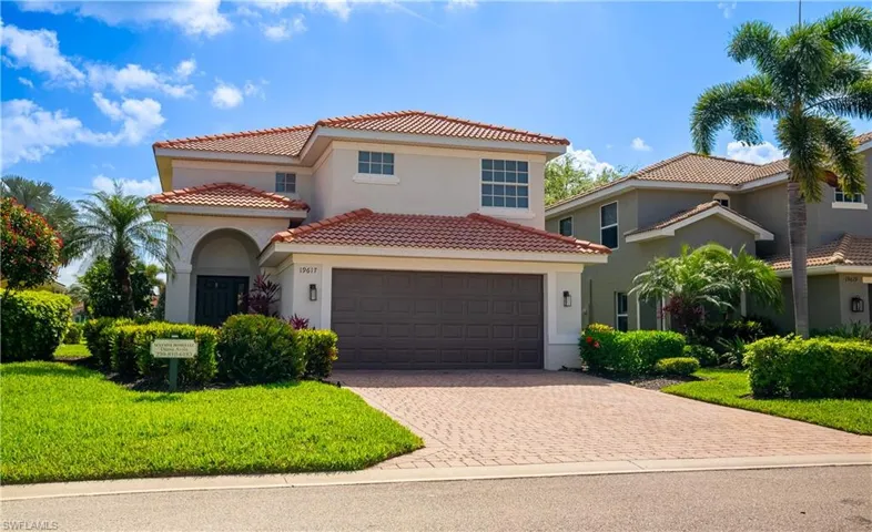 Mediterranean / spanish-style home with decorative driveway, stucco siding, a tiled roof, and a front yard